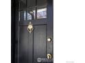 Close-up of a beautiful black front door featuring a gold door knocker at 2424 4Th St, Boulder, CO 80304