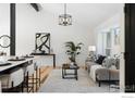 Open concept living room with gray sofa, wood floors, and large windows at 4223 Peach Way, Boulder, CO 80301