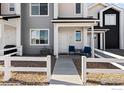 Modern townhome exterior with gray siding, white trim, and small front porch at 500 S Denver Ave # 2B, Fort Lupton, CO 80621