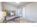 Bright home office with built-in shelving and view of kitchen at 605 Wild Honey Dr, Berthoud, CO 80513