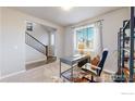 Home office features a desk, chair, and view of staircase at 605 Wild Honey Dr, Berthoud, CO 80513