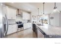 Modern kitchen with stainless steel appliances and granite countertops at 605 Wild Honey Dr, Berthoud, CO 80513