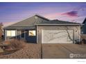 Gray ranch style home with a two-car garage at dusk at 622 Beth Ave, Fort Lupton, CO 80621