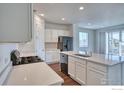 Modern kitchen with white cabinets, island, and stainless steel appliances at 6325 Copper Dr, Erie, CO 80516