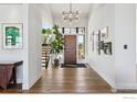 Bright and airy entryway with hardwood floors and modern light fixture at 635 Paragon Dr, Boulder, CO 80303