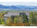 A modern home featuring mountain views, with a gray roof and mature trees at 635 Paragon Dr, Boulder, CO 80303