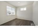 Bright bedroom featuring dark wood floors and a window with blinds at 6530 13Th St, Frederick, CO 80530