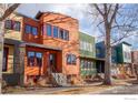 Street view of colorful modern townhomes with well-maintained front yards at 820 Tenacity Dr, Longmont, CO 80504