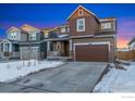 Two-story house with brown siding, attached garage, and snowy front yard at 850 Mosquito Ct, Elizabeth, CO 80107