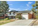 This two-story home features an attached garage, manicured landscaping, and a brick and painted siding exterior at 1055 Jade St, Broomfield, CO 80020