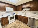 Condo kitchen with white appliances and wood cabinets at 13631 E Marina Dr # 108, Aurora, CO 80014