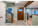 Bright entryway with a staircase, wood door, and view to the living room at 14117 W 58Th Pl, Arvada, CO 80004