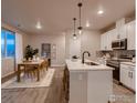 Bright dining area adjacent to the kitchen, with a wooden table and rug at 1438 Coral Pl, Longmont, CO 80504