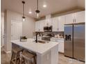 Modern kitchen featuring white cabinets, stainless steel appliances, and an island at 1438 Coral Pl, Longmont, CO 80504