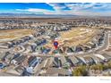 Aerial view of the community showcases houses with neighborhood amenities and snow-capped mountains in the distance at 15813 Xanthia Way, Thornton, CO 80602