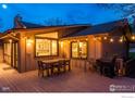 Back patio with outdoor dining and grill, string lights, and kitchen view at 1715 View Point Rd, Boulder, CO 80305