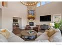 Living room with stone fireplace, high ceilings, and ample natural light at 19064 Eagle Ridge Dr, Golden, CO 80401