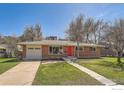 Brick ranch home with red door, attached garage, and landscaped yard at 2000 Edgewood Dr, Boulder, CO 80304