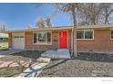 Brick ranch home with red door, attached garage, and landscaped yard at 2000 Edgewood Dr, Boulder, CO 80304