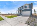 Two-story home with gray siding, white trim, and a two-car garage at 2245 Base St, Fort Lupton, CO 80621