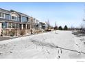 Row of townhomes with snowy yard and open space at 257 Jackson Dr, Erie, CO 80516