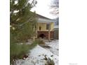 Cute yellow house with snowy front yard and brick accents at 350 Florence Ave, Firestone, CO 80520