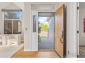 Inviting entryway with a wooden door, bright natural light, and hardwood floors at 440 Andrew Way, Superior, CO 80027