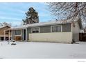 Gray house with a snow covered front yard at 5332 Granby St, Denver, CO 80239