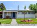Well-kept single-story home with a cozy front yard, stone walkway, and painted brick facade at 5332 Granby St, Denver, CO 80239