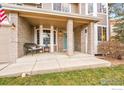 Covered porch with brick columns, a sitting area, and a welcoming entryway at 5508 Triple Crown Dr, Frederick, CO 80504