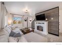 Bright and airy living room with a fireplace, sleek wood paneling, and abundant natural light at 673 Country Road N Trl, Berthoud, CO 80513