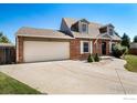 Charming brick home featuring a well-manicured lawn and an attached two-car garage at 719 Marshall Pl, Berthoud, CO 80513