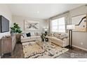 Living room with comfy sofas, coffee table, and large windows at 824 Ledge St, Lochbuie, CO 80603