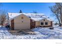 Two-story home with attached garage, snow-covered driveway, and mature trees at 12900 N 66Th St, Longmont, CO 80503