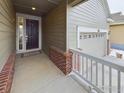 Inviting front porch with brick accents and a storm door, offering a warm welcome to the home at 1465 Otis Dr, Longmont, CO 80504