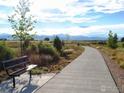 Picturesque walking path with a bench and mountain views, ideal for enjoying nature and outdoor recreation at 1465 Otis Dr, Longmont, CO 80504