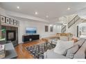 Open-concept living room with hardwood floors, fireplace, TV and staircase to upper level at 154 S Jackson St, Denver, CO 80209