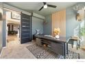 Home office with a sliding barn door, a patterned rug, and views of living spaces at 2483 Tabor St, Berthoud, CO 80513