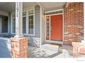 Inviting front entrance with a brick walkway and an orange door at 2855 Rock Creek Cir # 191, Superior, CO 80027