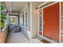 Side view of the home's entrance with brick accents and an orange door at 2855 Rock Creek Cir # 191, Superior, CO 80027