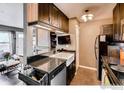 Modern kitchen featuring dark cabinets, granite countertops, stainless steel appliances, and a farmhouse sink at 3025 Broadway St # 40, Boulder, CO 80304