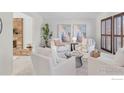 Bright living room with white armchairs, decorative artwork and a brick fireplace at 4302 Apple Way, Boulder, CO 80301