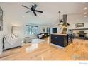 Open-concept living space with a kitchen island, hardwood floors, and contemporary lighting at 4667 Harwich St, Boulder, CO 80301