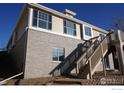 Side view of property showing stairwell entrance and multiple windows at 5065 S Haleyville St, Aurora, CO 80016