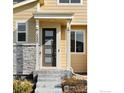 Modern front door with stone accents and steps at 5335 Spalding Pl, Frederick, CO 80504