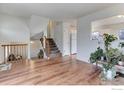 Bright living room with hardwood floors, staircase, and neutral paint; abundant natural light at 614 Glenwood Dr, Lafayette, CO 80026