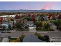 Aerial view of house and neighborhood with mountain views in autumn at 615 Allen Dr, Longmont, CO 80503