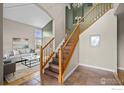 Bright entryway with tiled floor, wooden staircase, and view to living room at 615 Allen Dr, Longmont, CO 80503