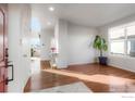 Bright entryway featuring hardwood floors, white walls, and a view into the living area at 6433 Eagle Butte Ave, Frederick, CO 80516