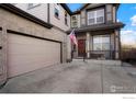 Close up of a garage with large driveway and covered porch, perfect for welcoming guests at 6433 Eagle Butte Ave, Frederick, CO 80516